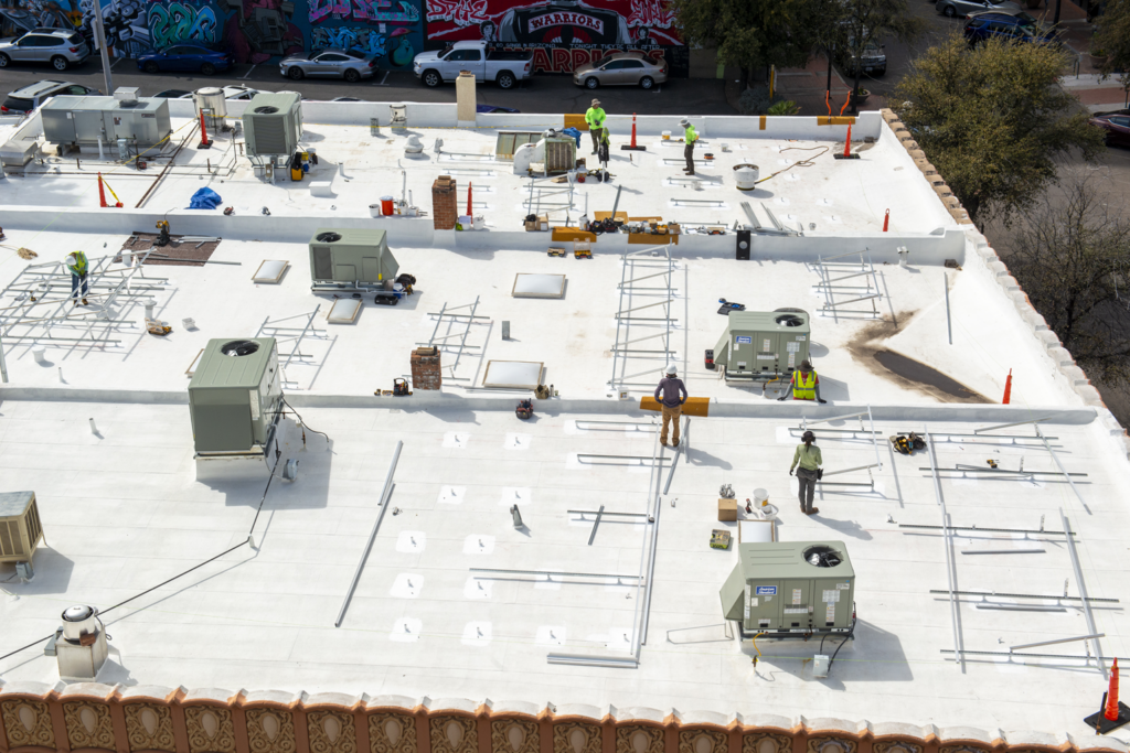 Construction workers on a roof complete a capital improvement project.